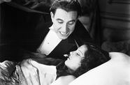 Masculine vampire lurks next to the bed of a sleeping woman 