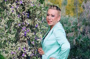 Photo portrait of activist Bamby Salcedo looking over her should at the camera
