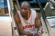 Man leans out of car door wearing gold chain