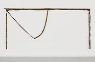 A colorful, yarn wrapped piece hanging on a wall