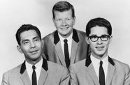Black and white image of three men in matching suits