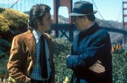 Two men talk with the Golden Gate bridge behind them