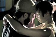A man and a woman slow dance, their foreheads pressed together