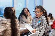 A girl reads from a piece of paper