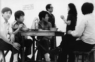 Image of men eating and drinking at a table in the middle of an art gallery