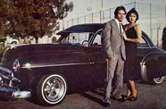 Photo of a couple standing in front of a vintage car