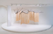 Wood branches suspended from the ceiling, with long strips of paper hanging down from them