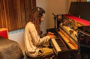 Musician Jamael Dean sits at a piano