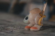 An anthropomorphized shell wearing a homemade backpack