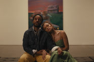 A Black couple look together at an artwork in a museum