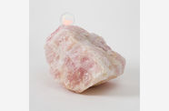 A large pink quartz with a disc-shaped memory crystal embedded in its top