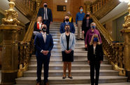 Ten people standing on an ornate staircase