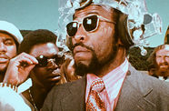 Image of a Black man wearing sunglasses and a futuristic headpiece