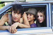 The faces of three young adults framed in a car window