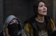 Two women, one wearing a bandana over her face