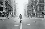 Harry Belafonte pulls a wagon behind him as he walks through a desolate city street