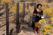 Krystle Hickman stands in a nature preserve holding a camera
