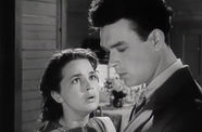 a young lady looking at another young man in suit