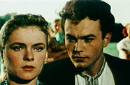 a man in suit starring at another woman next to him