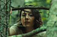 A girl gazing through a tree branch