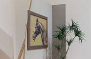 an installation with a plant, a painting hanging on a broken wall