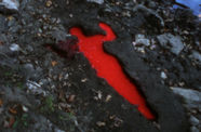 A silhouette dug into the dirt, filled with bright red liquid