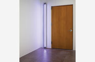 A photo of a door with a purple fluorescent light beside it