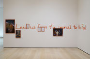 Artwork consisting of a number of framed photographs and watt text reading "Lead us from the unreal to the Real"