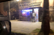 Video taken from a moving car while passing a corner store with sign reading "FIGUEROA MARKET," neon lights glowing from inside the building