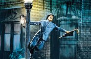 Gene Kelly spins around a lamppost in the rain