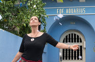 A woman stands in front of a building marked EDF AQUARIUS