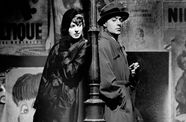 Ingrid Bergman and Charles Boyer stand back to back, a lamppost between them