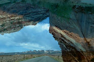 A composite landscape with a remote highway and a large rock formation