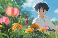 A cartoon boy looks at a tiny girl standing on a flower
