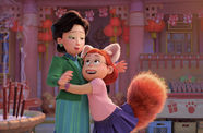 A girl with furrey ears and a large tail sticking out of her skirt hugs an older woman