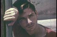 Close up of a young man leaning against a pole