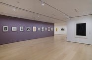 Gallery with framed works on paper mounted on the wall