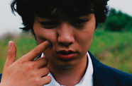 Close-up of a young man's face, with a finger pointing into their cheek