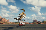 A cartoon coyote wearing ACME brand rollerblades stands on an empty desert highway