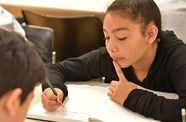 Child writing in a notebook.