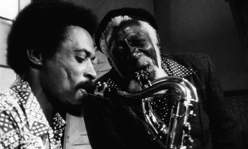 Two men play the saxaphone