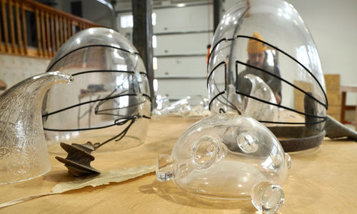 Blown glass shapes, through which is visible a distorted view of the artist