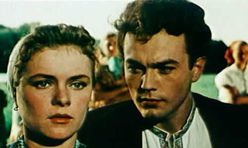 a man in suit starring at another woman next to him