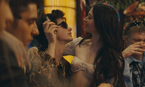 a young man holding another young woman in a bar