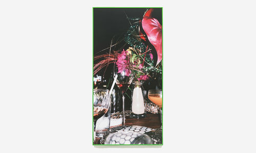 Photo of a tablescape including a wine glass and flower arrangement