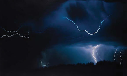 Lightning striking in the dark sky