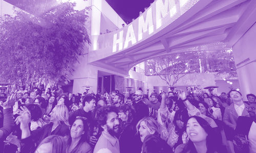 A crowded museum courtyard full of smiling, dancing visitors