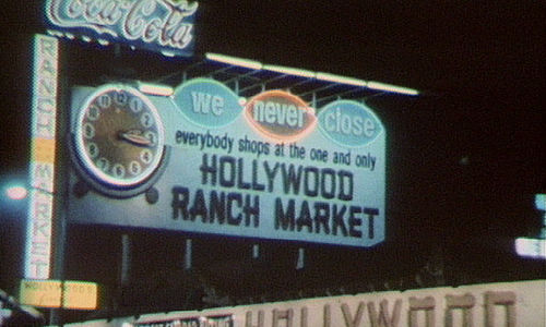 Large billboard sign with a clock reading: We Never Close - Hollywood Ranch Market"