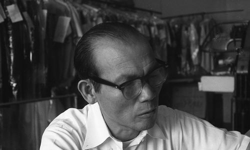 Black and white still of a man in a dry cleaning business