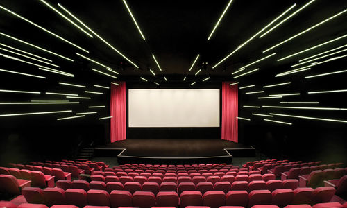 An empty movie theater with pink curtains and seats